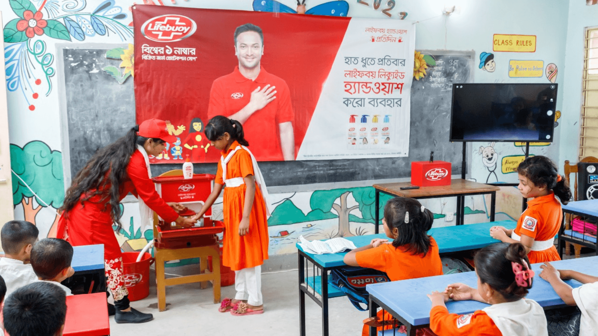 A woman teaching a student how to wash hands properly with Lifebuoy, as part of a rural school activation programme.