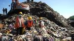 Three waste workers are working in the landfill