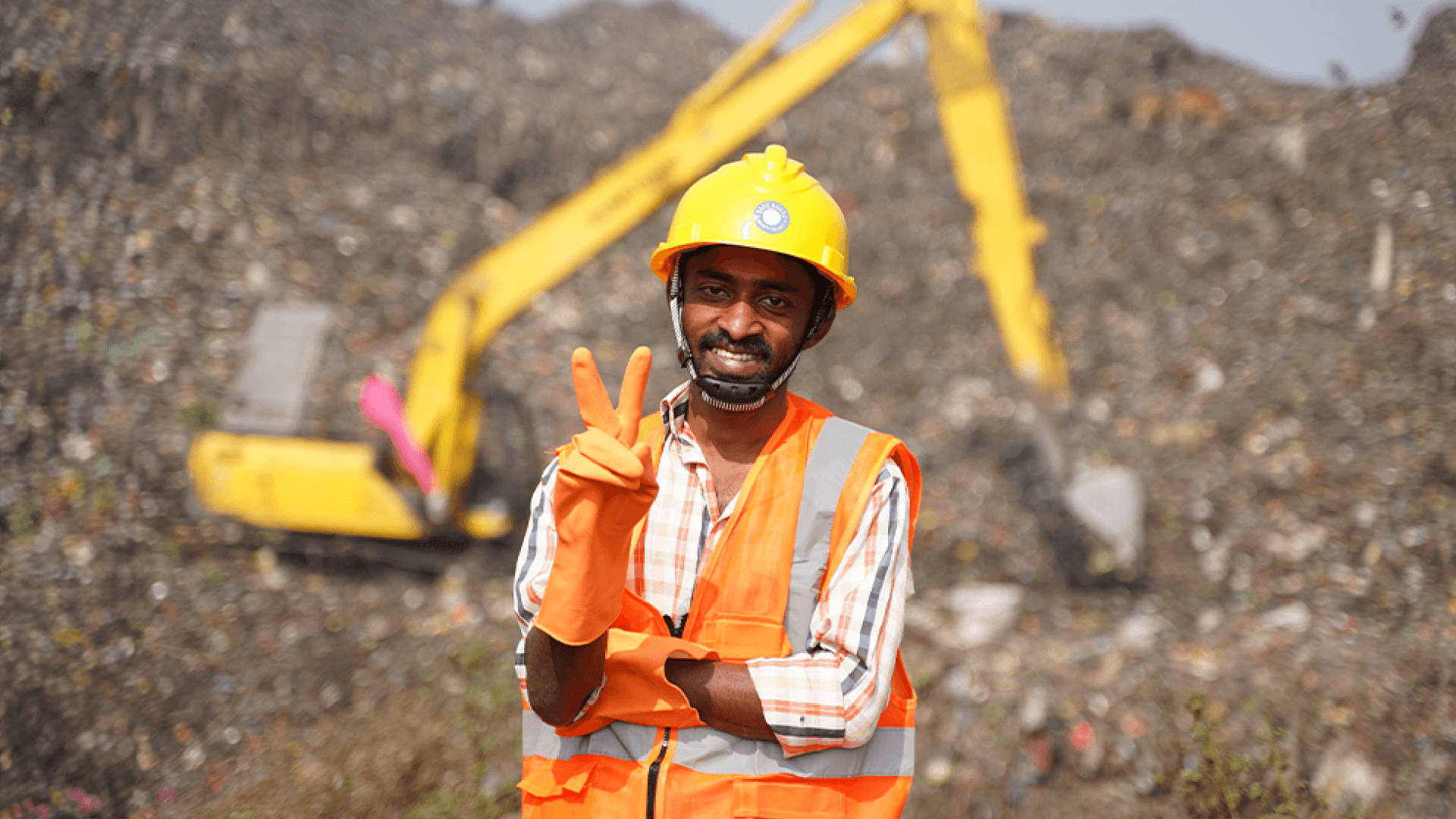 Photo of a smiling male plastic waste sorting worker