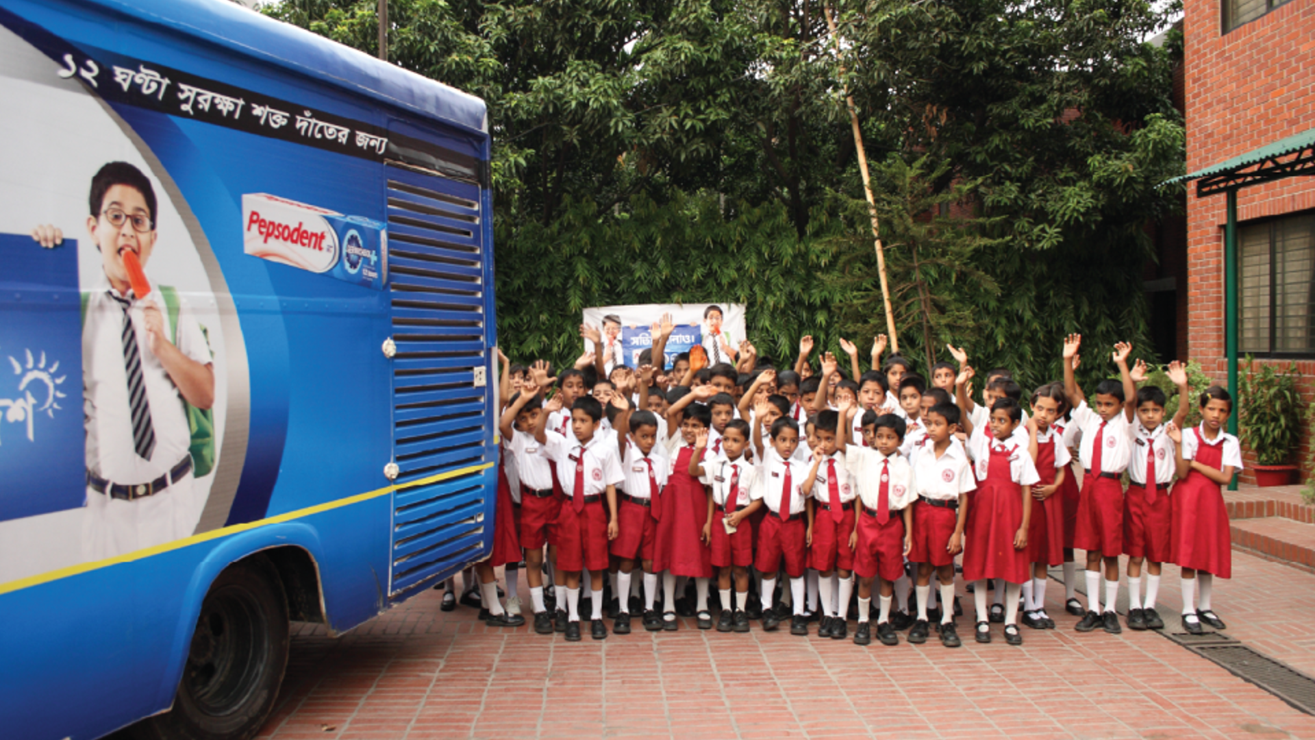 Group picture of school-going kids cheering and participating in a Pepsodant campaign.