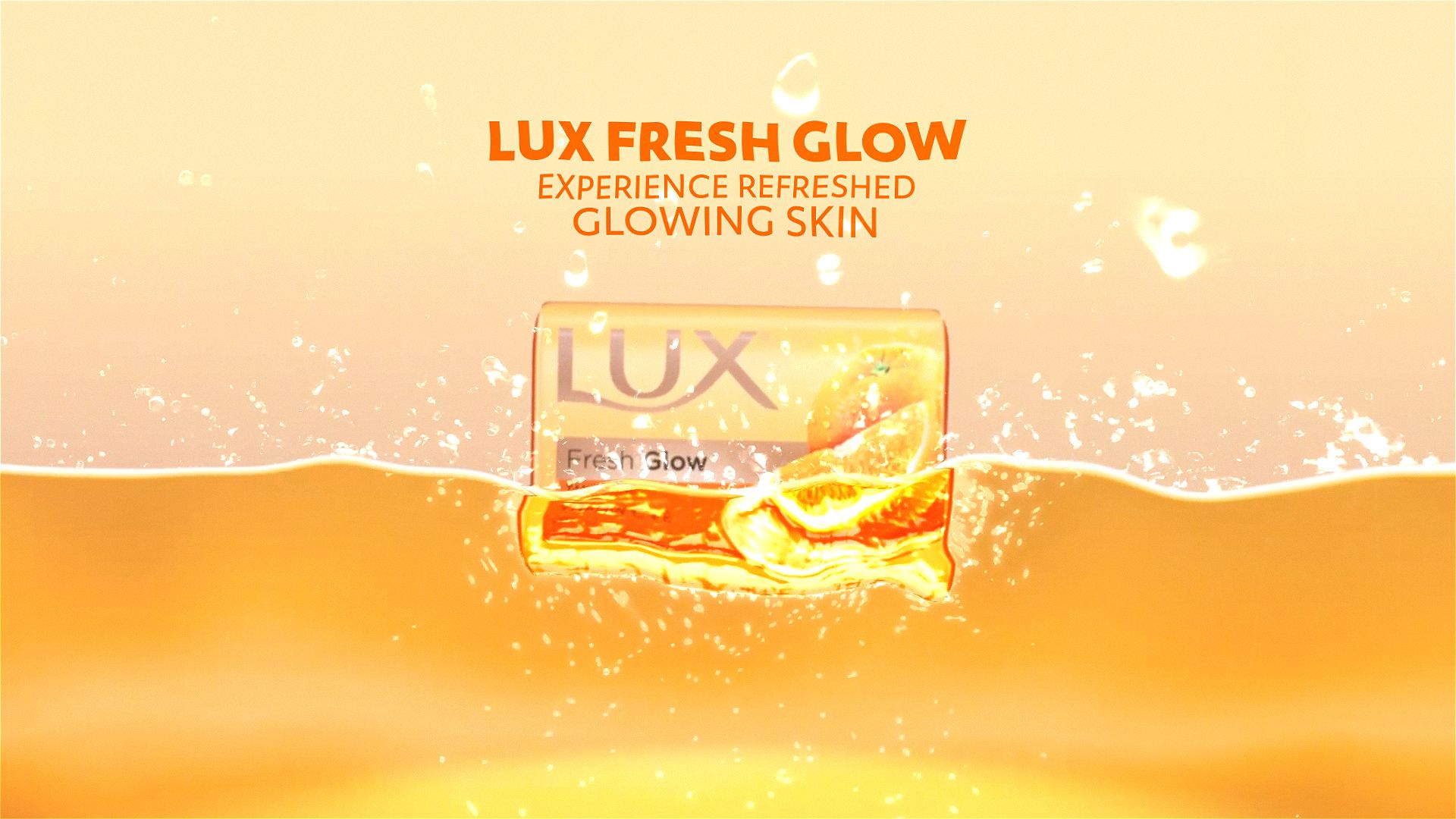 LUX Fresh Glow soap bar in a sea of tangerine freshness