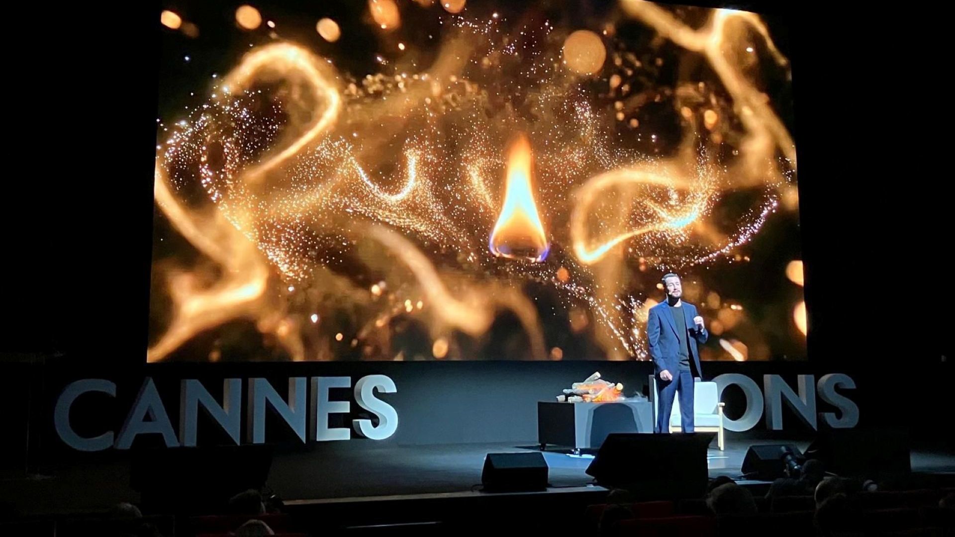 Leandro Barreto on stage at Cannes Lions delivering his keynote speech in front of a photo of a flames.